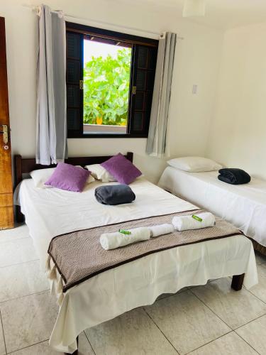 two beds in a room with towels on them at Pousada Piratininga in Niterói