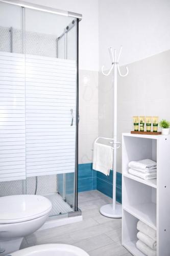 a bathroom with a shower and a toilet and a sink at INAH Rooms in Dorgali