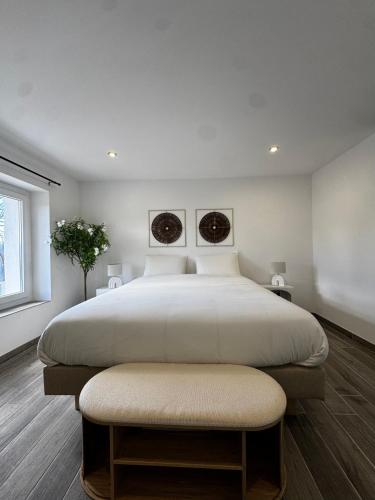 a bedroom with a large bed with a ottoman at Maison avec Jacuzzi Privatif Calme Soleil Cote d Azur in La Crau