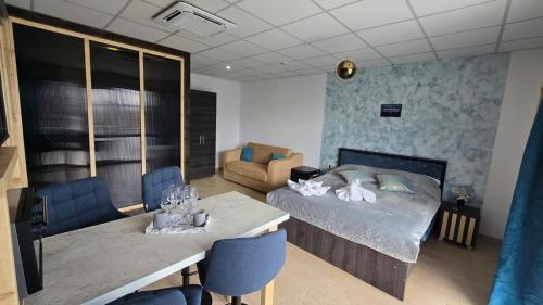 a bedroom with a bed and a table and a couch at Totall Panoramic Studio in Moreni