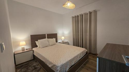 a bedroom with a bed with two night stands and two lamps at Malu in Pinhal do Douro