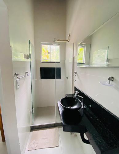 a bathroom with a sink and a glass shower at Pousada Piratininga in Niterói