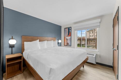 a large white bed in a room with a window at Everhome Suites Somerset - South Brunswick by Choice Hotels in Somerset