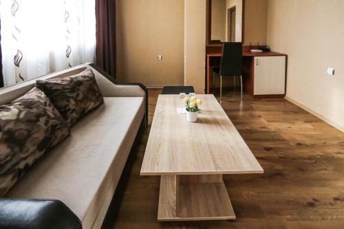 a living room with a couch and a coffee table at Sharkov Family Hotel in Ognyanovo