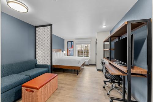 a living room with a couch and a tv and a bed at Everhome Suites Somerset - South Brunswick by Choice Hotels in Somerset