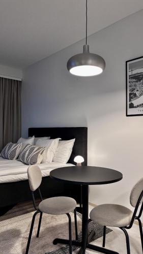 a bedroom with a bed and a table and chairs at Borg Areena - Stylish Studio Apt For 3 in Tampere
