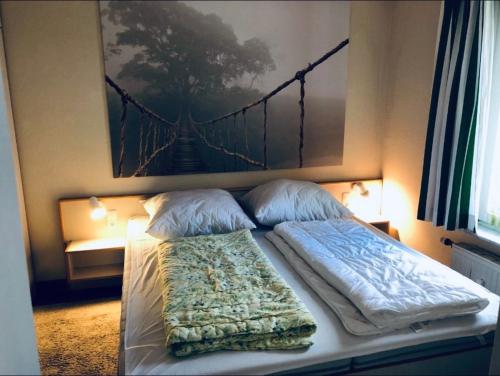 a bed with two pillows and a painting on the wall at Ocean View Laboe in Laboe