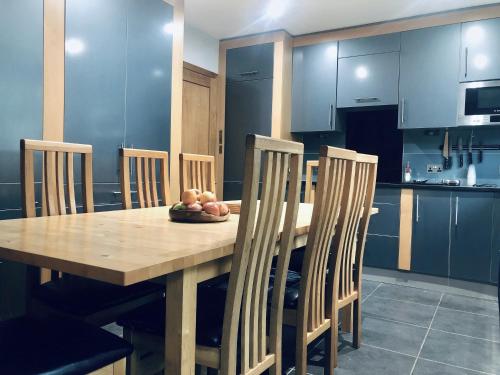 a kitchen with a wooden table and chairs with fruit on it at Bassett Home - Double room and Free Parking in Southampton