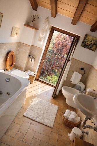 a bathroom with a tub and a sink and a window at La Locanda Del Tevere Slow tourism near Rome in Fiano Romano
