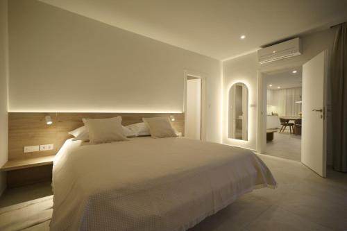 a bedroom with a large white bed and a dining room at Apartments Bianca Vodice in Vodice