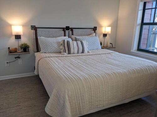 a bedroom with a large bed with two lamps on it at Renovated Chic Premium 1 bdrm in Vernon Township