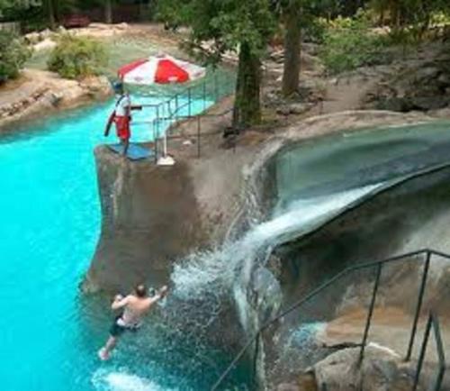 a man in a swimming pool with a waterfall at Appalachian TOP 4TH FLOOR Studio plus amazing views in Vernon Township