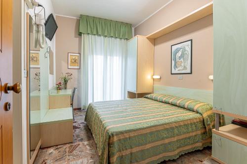 a hotel room with a bed and a bathroom at Hotel Cannes in Bellaria-Igea Marina