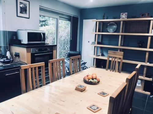 a kitchen with a wooden table with a bowl of fruit on it at Bassett Home - Double room and Free Parking in Southampton