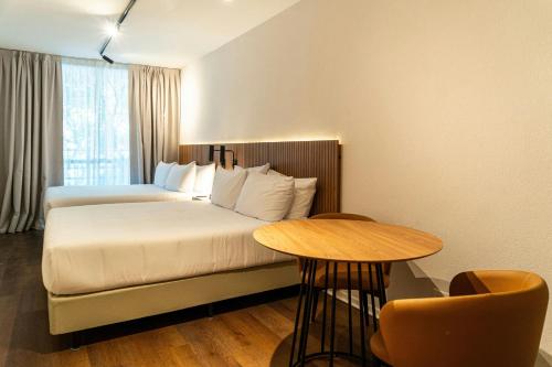 a hotel room with a bed and a table at City Express Plus by Marriott Buenos Aires Palermo in Buenos Aires