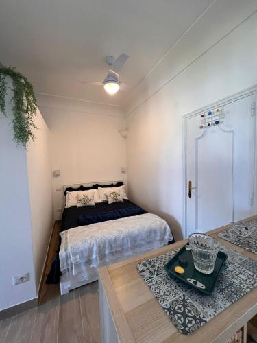 una pequeña habitación con una cama y una mesa en casa Ricciulella, en Capri