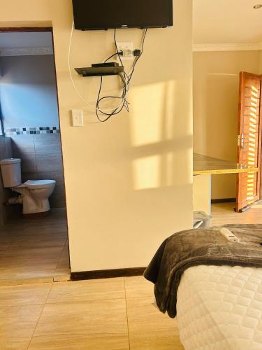 a bedroom with a door to a bathroom with a toilet at Rainow guest house in Burgersfort