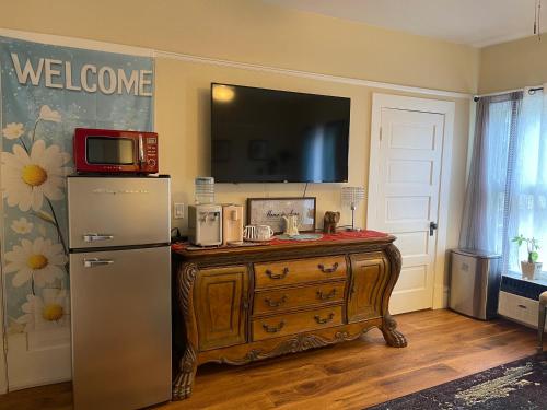 a kitchen with a refrigerator and a television on a wall at Suite in Downtown Riverside in Riverside