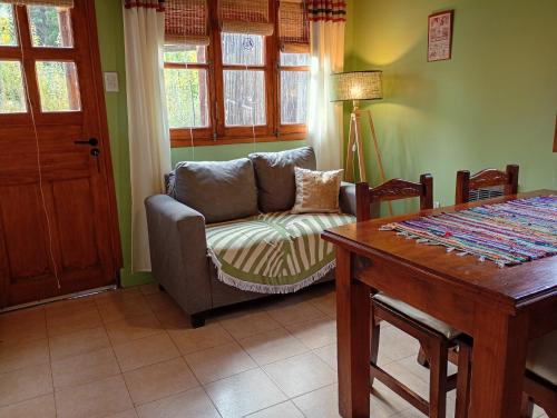 a living room with a couch and a table at Cabañas Rowal Potrerillos in Potrerillos