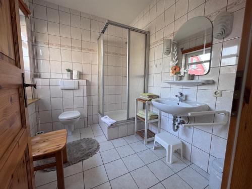 a bathroom with a sink and a shower and a toilet at Zum Fahrensmann in Norddorf