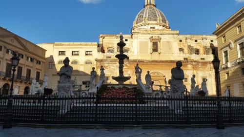 a building with a fountain with statues in front of it at Appartamenti Vittorio Emanuele in Palermo