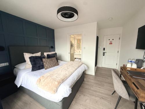 a bedroom with a large bed with a desk and a desk at United Home B&B in Manchester