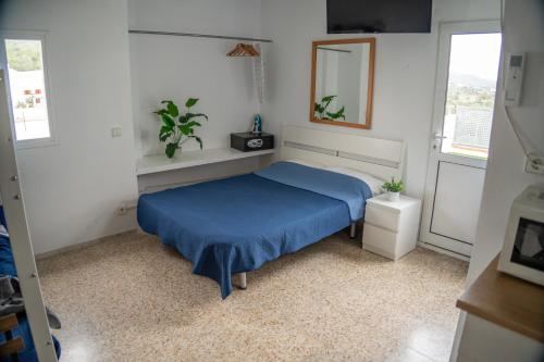 a bedroom with a blue bed and a mirror at Le Mirage Ibiza in San Antonio