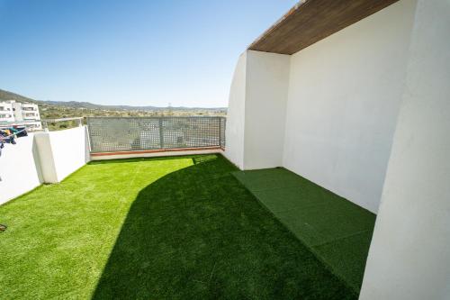 a balcony with green grass on the side of a building at Le Mirage Ibiza in San Antonio