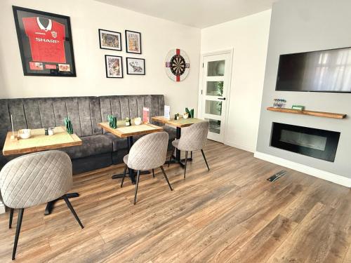 a dining room with two tables and a couch at United Home B&B in Manchester