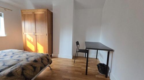 a bedroom with a desk and a bed and a cabinet at Bitterne Homestay in Southampton