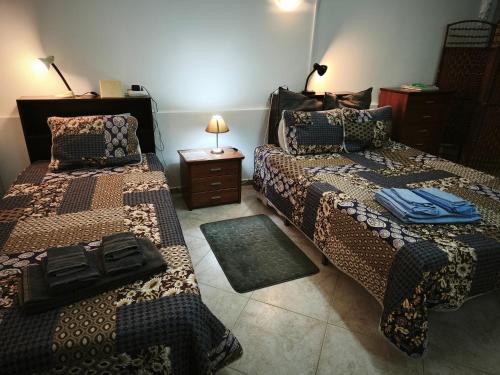 a room with two beds and a table with a lamp at Quinta do Medronhal Faro - casas de férias medronhal in Faro