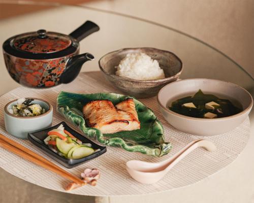 a table with a plate of food and bowls of rice at Okaeri in Calistoga