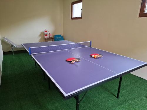 a purple ping pong table in a room with at Little Bear Busteni 3 - Închiriere integrală, cameră de jocuri, parcare privată, potrivită și pentru munca la distanță in Buşteni