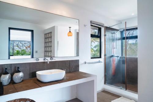 a bathroom with a sink and a shower at Villa Baki - Luxe & Ocean View in Le Morne