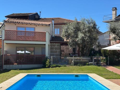 a villa with a swimming pool in front of a house at 6 bedroom countryhouse with pool - Casa do Sepião in Vinhal