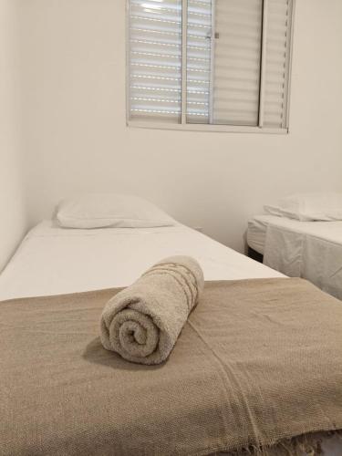 a towel laying on a bed in a bedroom at Lua da Mantiqueira - Staffy House Extrema in Extrema