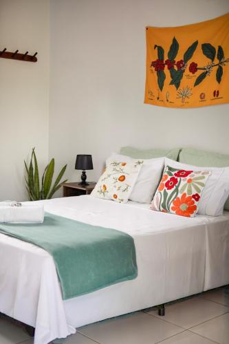 a bedroom with a white bed with pillows on it at Sabiá Hospedagem - São Jorge in Sao Jorge