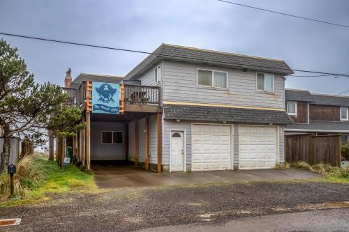 a house with a balcony and a garage at Friend-Ship in Rockaway Beach