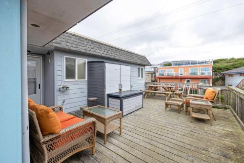 a balcony with a couch and chairs on a deck at Friend-Ship in Rockaway Beach
