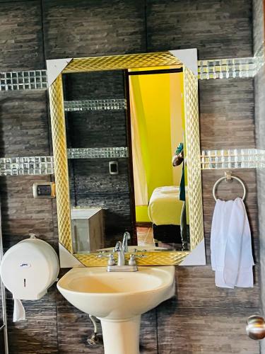 a bathroom with a sink and a mirror at Amazon Jade Hotel Boutique in San Bartolomé Milpas Altas