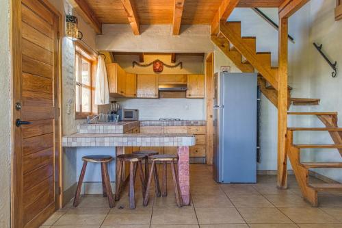 a kitchen with a refrigerator and some bar stools at Cabaña Andrea y Sofía in Mazamitla