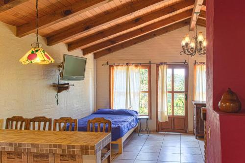 a bedroom with a bed and a table with chairs at Cabaña Andrea y Sofía in Mazamitla