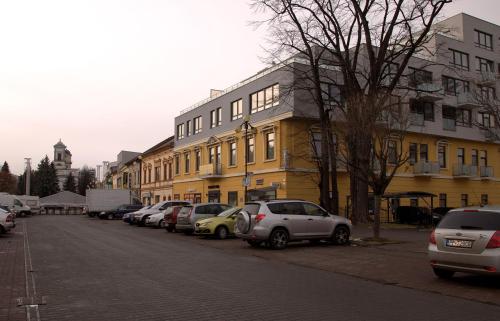 a row of cars parked in front of a yellow building at Apartment Centrum number 8 in Poprad