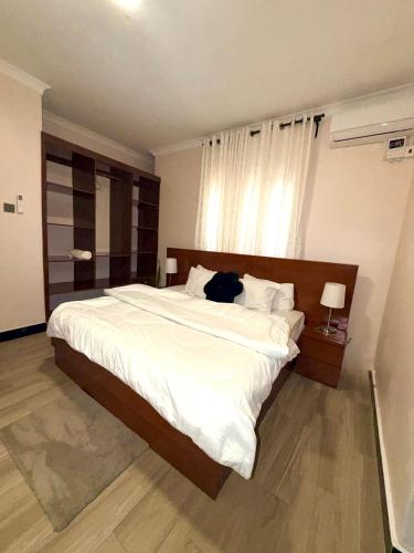 a bedroom with a large bed with white sheets at Oasis Residence in Arusha