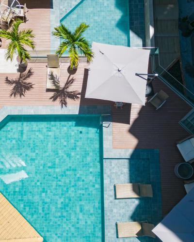 an overhead view of a swimming pool with an umbrella at San Marino Suite Hotel in Maceió