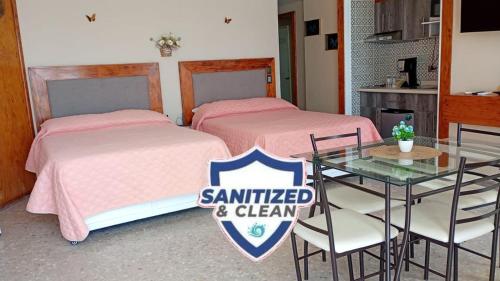 a room with two beds and a table with a sign at Torres Gemelas Suite VIP Frontal 607 in Acapulco