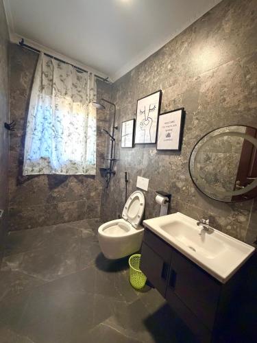a bathroom with a toilet and a sink and a mirror at Oasis Residence in Arusha