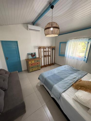 a bedroom with a bed and a couch in it at Casinha Branca MSP - Casa na Quarta Praia in Morro de São Paulo