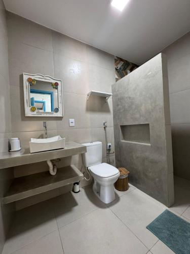 a bathroom with a white toilet and a sink at Casinha Branca MSP - Casa na Quarta Praia in Morro de São Paulo