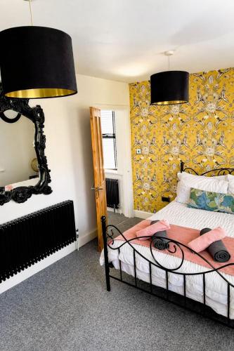 a bedroom with a bed and a yellow wall at Coastal Nest in Hollington